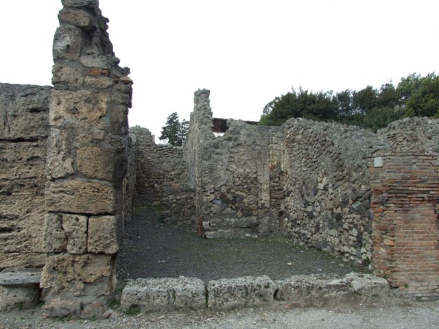 V.2.9 Pompeii. May 2010. West wall of shop, with lararium niche.