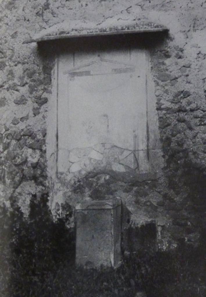 V.2.15 Pompeii. Old undated photograph. Garden 11c. North wall. Lararium.
The Notizie degli Scavi records a panel of white stucco.
On this is painted an aedicula, which Boyce says is painted in blue, yellow, dark red and green.
Within the aedicula is a painting of Giove (Jupiter) seated on a throne.
Underneath is a masonry altar covered with white plaster. 
See Notizie degli Scavi di Antichit�, 1894, p. 439.
See Boyce G. K., 1937. Corpus of the Lararia of Pompeii. Rome: MAAR 14.  (96, p.35, Pl 39,3).
