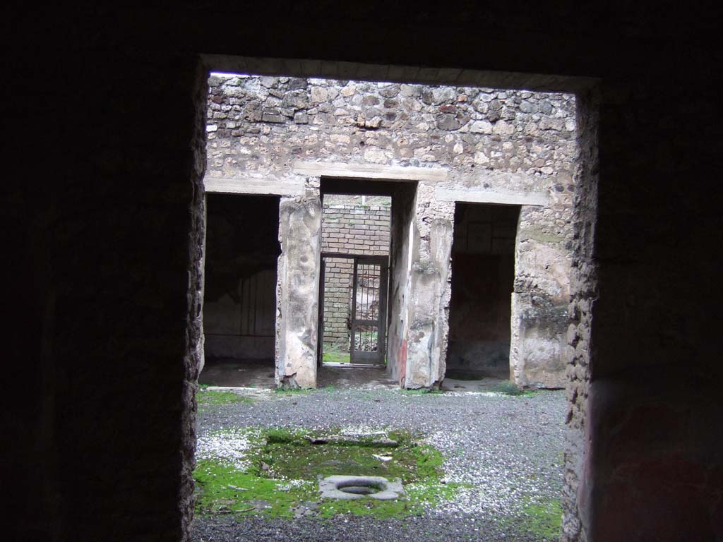 V.2.h Pompeii. December 2005.
Looking north from tablinum ‘f’, across atrium towards entrance fauces ‘a’ and two doorways to cubicula on either side.
The doorway on the left leads into the cubiculum ‘b’ on the west of the fauces. Cubiculum ‘c’ is on the right.