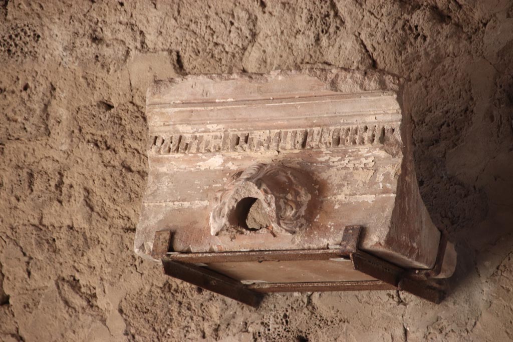 V.2.i Pompeii. October 2023. Tablinum 7, waterspout on display against west wall. Photo courtesy of Klaus Heese.