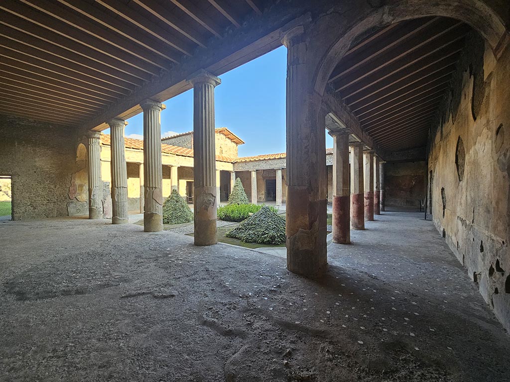 V.2.i Pompeii. November 2024.
Looking east across north portico, on left, and looking south along west portico, on right.Photo courtesy of Annette Haug.