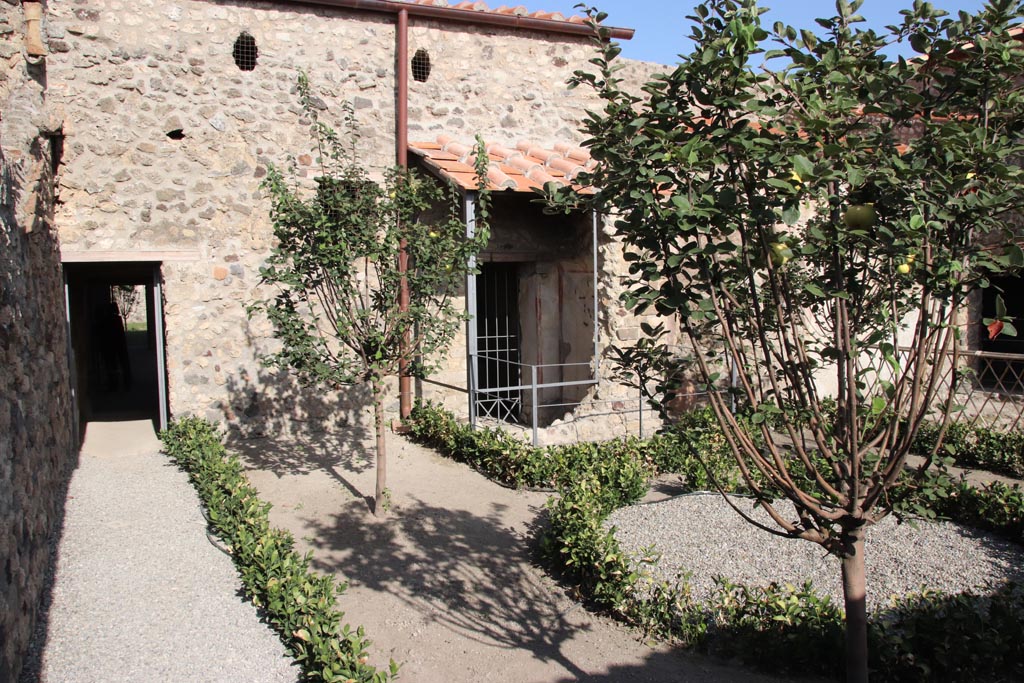 V.2.i Pompeii. October 2023.
Looking east across garden, with doorway to kitchen on left, and latrine in centre. Photo courtesy of Klaus Heese.