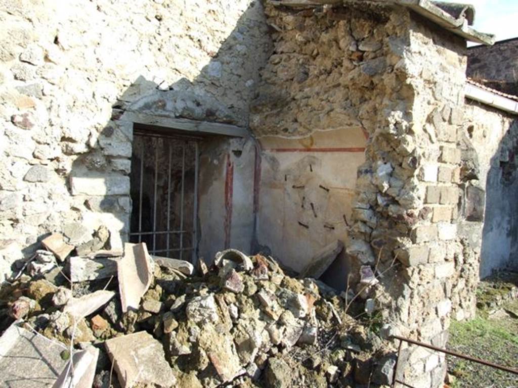 V.2.i Pompeii. December 2007. Room 13. Painted latrine. Collapsed wall viewed from garden with entrance to room 11 (kitchen) at rear of latrine.