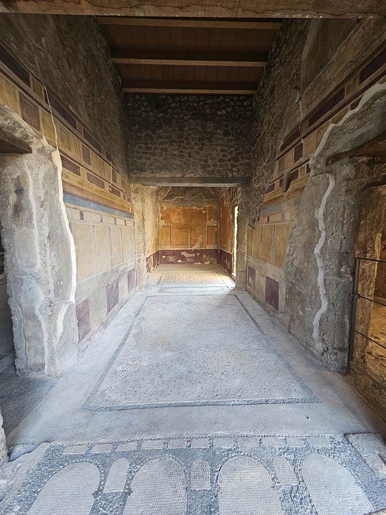V.2.i Pompeii. November 2024.
Room 14, looking west from peristyle across antecamera of apodyterium or dressing room.
Photo courtesy of Annette Haug.