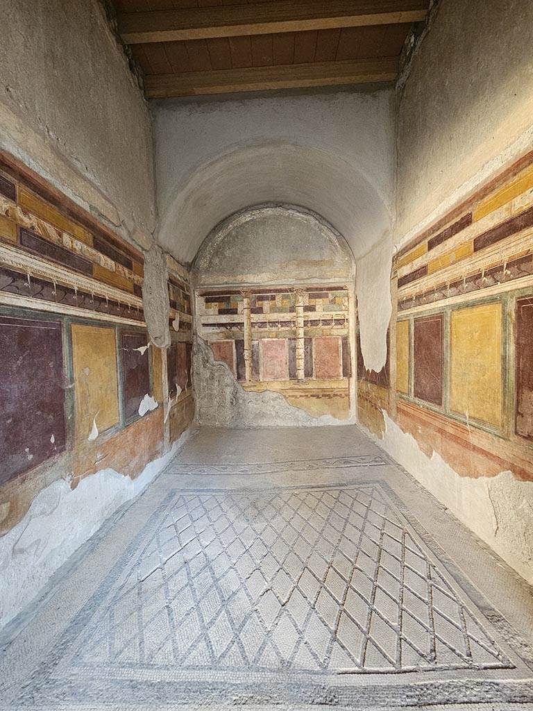 V.2.i Pompeii. November 2024.
Room 20, looking south across mosaic flooring towards rear area for a couch. Photo courtesy of Annette Haug.