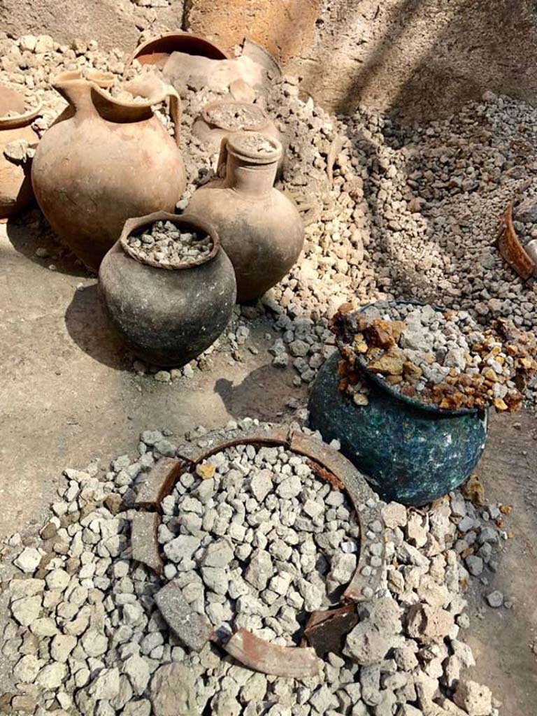 Regio V Pompeii. 2018. The richer finds were found inside the House of Jupiter, concentrated essentially in two rooms.
In particular, the floor of the room decorated in the 1st style was completely covered with thick and bronze vases, of various types, which in all likelihood had been carefully stored in that room due to the renovations in progress inside the domus.
Più ricca la suppellettile ritrovata all’interno della Casa di Giove, concentrata essenzialmente in due stanze. In particolare, il piano pavimentale dell’ambiente decorato in I stile era completamente coperto di vasi fittili e bronzei, di varia tipologia, che con ogni probabilità erano stati accuratamente riposti in quel vano a causa dei lavori di ristrutturazione in corso all’interno della domus.
Photograph © Parco Archeologico di Pompei.