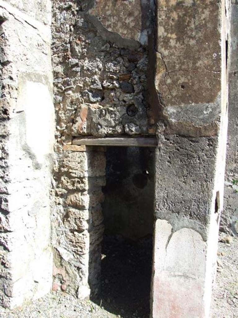 V.4.3 Pompeii. March 2009. Doorway to cupboard in north-east corner of atrium. West wall.
According to Boyce, items were found among the ruins of two cupboards in the room to the east of the atrium. They may have been found in this cupboard,  or else in the triclinium on the east side of the atrium (see part 1)? Together with a hoard of 130 silver and 54 bronze coins, also found were three bronze statuettes of the household gods. The Genius, and two Lares each holding cornucopia and patera and standing solidly on two feet. A marble statuette of Venus Anadyomene and a small marble altar may also have belonged to the shrine. He quoted Notizie degli Scavi di Antichit�, 1899, 206. See Boyce G. K., 1937. Corpus of the Lararia of Pompeii. Rome: MAAR 14. (p.40, no.118, note 1). See Giacobello, F., 2008. Larari Pompeiani: Iconografia e culto dei Lari in ambito domestico.  Milano: LED Edizioni. (p.240).