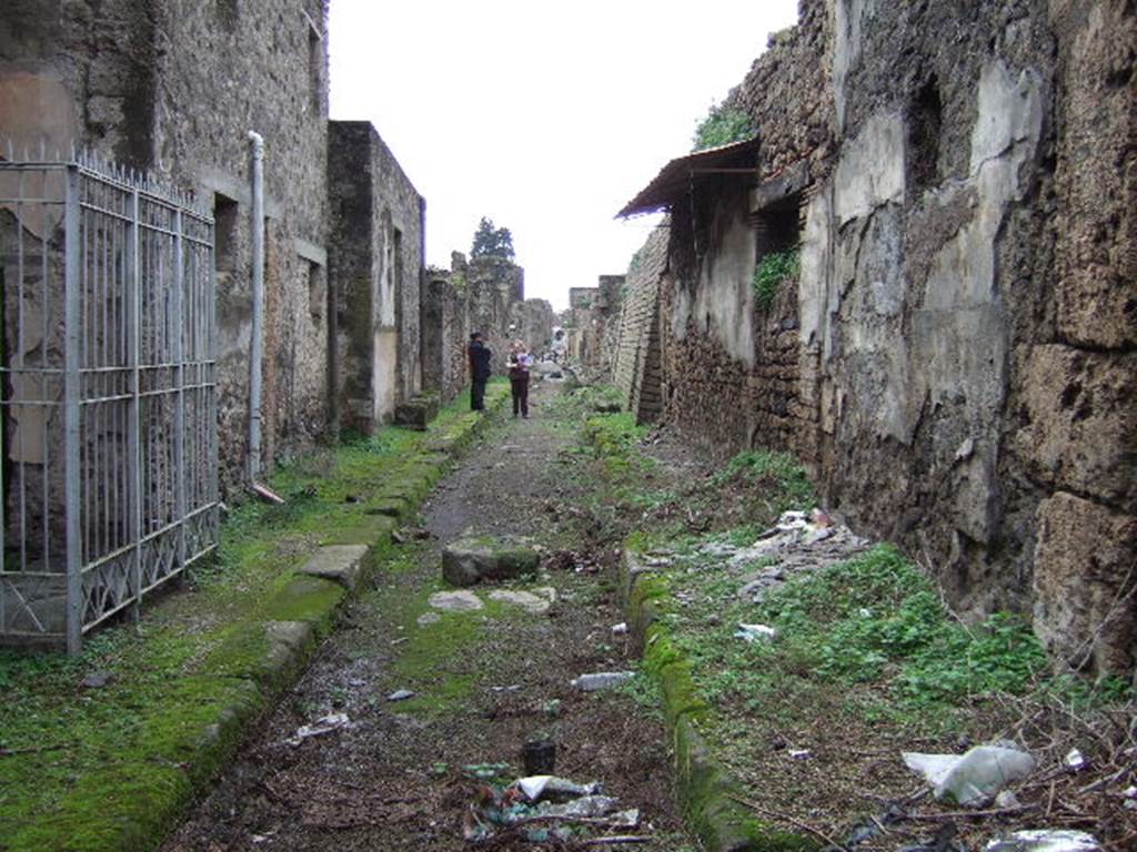 V.7.8 Pompeii. December 2005. Vicolo delle Nozze d�Argento looking west from V.7.7, on right, V.2.i on left.
Until the excavations in June 2018 the rest of the vicolo and V.7.8 behind the (invisible) photographer were still buried.