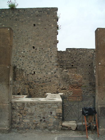 VI.2.1 Pompeii.  May 2005.  Looking from rear. Marble counter with six urns and a hearth.

