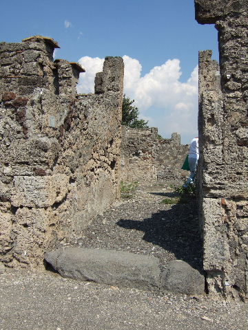 VI.2.11 Pompeii. Two doorways in north-west corner of atrium. On the left is the north wall of the entrance corridor. The doorway into the triclinium is next. Then the doorway into a cubiculum, with the west wall of the exedra/ala visible on the right.