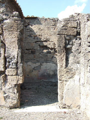 VI.2.11 Pompeii, can be seen on the left. May 2010. Looking east. Model as viewed in Naples Archaeological Museum. According to the model, at the rear of the atrium was a window overlooking the garden of house at VI.2.26. According to Fiorelli, this had a gate of iron and wood. See Pappalardo, U., 2001. La Descrizione di Pompei per Giuseppe Fiorelli (1875). Napoli: Massa Editore. (p.50)