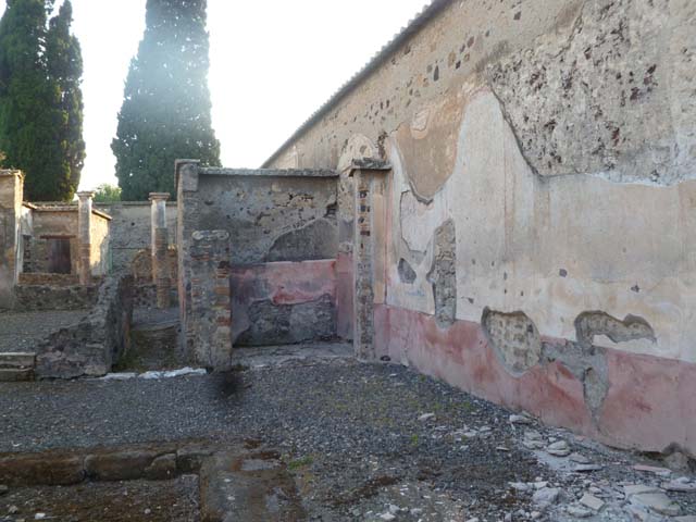 VI.2.22 Pompeii. May 2010. Looking east across peristyle, towards east wall. Model as viewed in Naples Archaeological Museum.
According to Giacobello, the wall with the aedicula was painted with a garden painting, not conserved. See Giacobello, F., 2008. Larari Pompeiani: Iconografia e culto dei Lari in ambito domestico.  Milano: LED Edizioni. (p.269)

