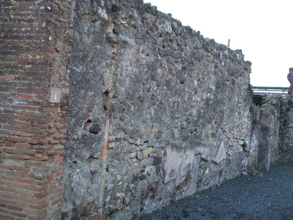 VI.4.4 Pompeii. December 2004. South wall from entrance.
According to Boyce, on this south wall, there was an outline of a large niche which seemed to have been originally a shrine.
This would have been opposite the lararium on the north wall.
This was probably filled in when the new shrine was painted.
See Boyce G. K., 1937. Corpus of the Lararia of Pompeii. Rome: MAAR 14. (p.46, no.151)
A down-pipe can be seen in the wall.