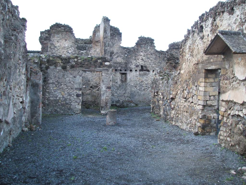 VI.4.4 Pompeii. December 2004. Looking west.
In the centre of the photo, next to the doorway in the west wall, can be seen the site of the latrine.
According to Garcia y Garcia, apart from the wear-and-tear of time, the disintegration of the sales counter was due to the bomb that fell to the south of the insula in 1943. In the hurried succeeding restoration, many elements and several structures have remained destroyed or have been forgotten.
In this hospitium, walls of the two latrines have been forgotten.
See Garcia y Garcia, L., 2006. Danni di guerra a Pompei. Rome: L’Erma di Bretschneider. (p. 75)
According to Hobson, at the rear of the property is a small room the northern wall of which is no longer standing, despite being shown on the plan.
This room has a sloping tile feature. There is a window where the latrine appears to be.
See Hobson, B. 2009. Pompeii, Latrines and Down Pipes. Oxford, Hadrian Books, (p. 202)
According to Boyce, another latrine may have been in the recess in the north-east corner of this room, near to the lararium on the north wall.
See Boyce G. K., 1937. Corpus of the Lararia of Pompeii. Rome: MAAR 14. (p. 46, no. 151).
