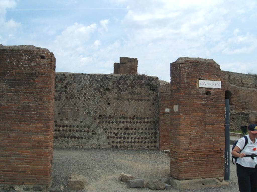 VI.6.20 Pompeii. May 2005. Looking east at entrance doorway of corner shop. According to Stefani, this was a large corner sales shop for the bakery at its rear. On the west wall was a lararium painting with serpent, on the facing wall was a supposed “cross”. This bakery was called “the bakery of the Christians” (Panificio dei Christiani) because of the relief in stucco, now vanished. This was found on the east wall of the shop, and was wrongly interpreted as a cross, the symbol of Christianity. See Stefani, G. (2005): Pompei. Un Panificio: in Cibi e Sapori a Pompei e dintorni, (p.139)
According to Della Corte, discovered in 1813 on the east wall in view of the road, was a panel of white stucco. On this panel in bas-relief was a Christian cross, although stylised, it was an object of veneration found opposite the pagan lararium. See Della Corte, M., 1965. Case ed Abitanti di Pompei. Napoli: Fausto Fiorentino. (p.115)
