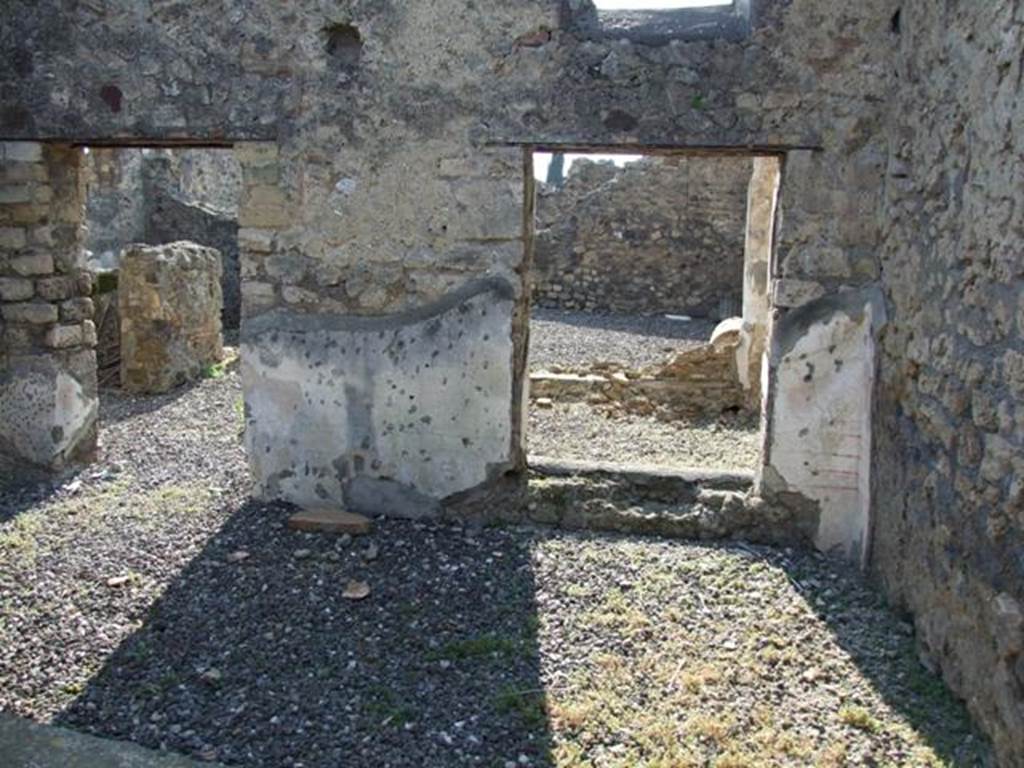 VI.7.1 Pompeii. March 2009. West wall.
Looking west from triclinium at rear of light-well, into open tablinum (left) and light-well (right).
In the corner next to the window to the light-well, the remains of the painted decoration can still be seen comprising of simple red lines on white background.