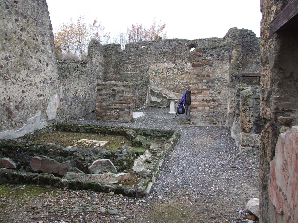VI.7.23 Pompeii. December 2006. Looking west across remains of pyramidal fountain in courtyard on west side of tablinum.
Painted remains of north wall and window, on right.