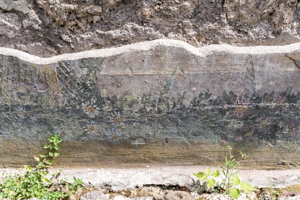 VI.7.23 Pompeii. July 2021.
Remains of painted trellis and flower garland from south wall of courtyard, behind fountain. Photo courtesy of Johannes Eber.