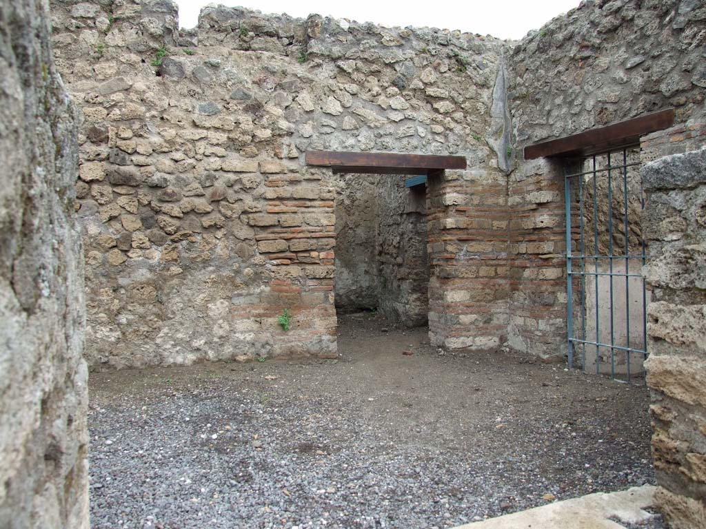 VI.8.9 Pompeii. May 2010.
Looking north into rear room, reached by two steps. The doorway, with blue gates, would have linked to VI.8.13.