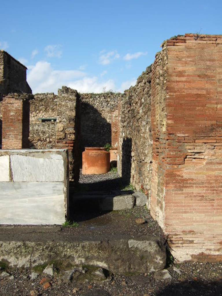 VI.8.10 Pompeii. December 2005. Looking north. According to Garcia y Garcia, there used to be a small pilaster that divided entrance 9 and 10, on the left in front of the counter. In 1943 a bomb fell on the road here, causing the destruction and loss of the pilaster. See Garcia y Garcia, L., 2006. Danni di guerra a Pompei. Rome: L�Erma di Bretschneider, (p.76).
According to Pagano and Prisciandaro, in March and April 1824 somewhere along the walls of the entrance 9 and 10, were found �
M(arcum) Cerrinium aed(ilem)
d(ignum) r(ei) p(ublicae) o(ro) v(os) f(aciatis) di<g=C>(nus) <e=I>s(t)    [CIL IV 264]
Licinium Faust(um)    [CIL IV 265]
written under, in red -  M(arcum) Cerrinium    [CIL IV 266]
Q(uintum) Postumium    [CIL IV 267]
L(ucium) Ceium
Secundum    [CIL IV 268]
See Pagano, M. and Prisciandaro, R., 2006. Studio sulle provenienze degli oggetti rinvenuti negli scavi borbonici del regno di Napoli.  Naples : Nicola Longobardi. (p. 129)  See PAH II,100; III, 50
