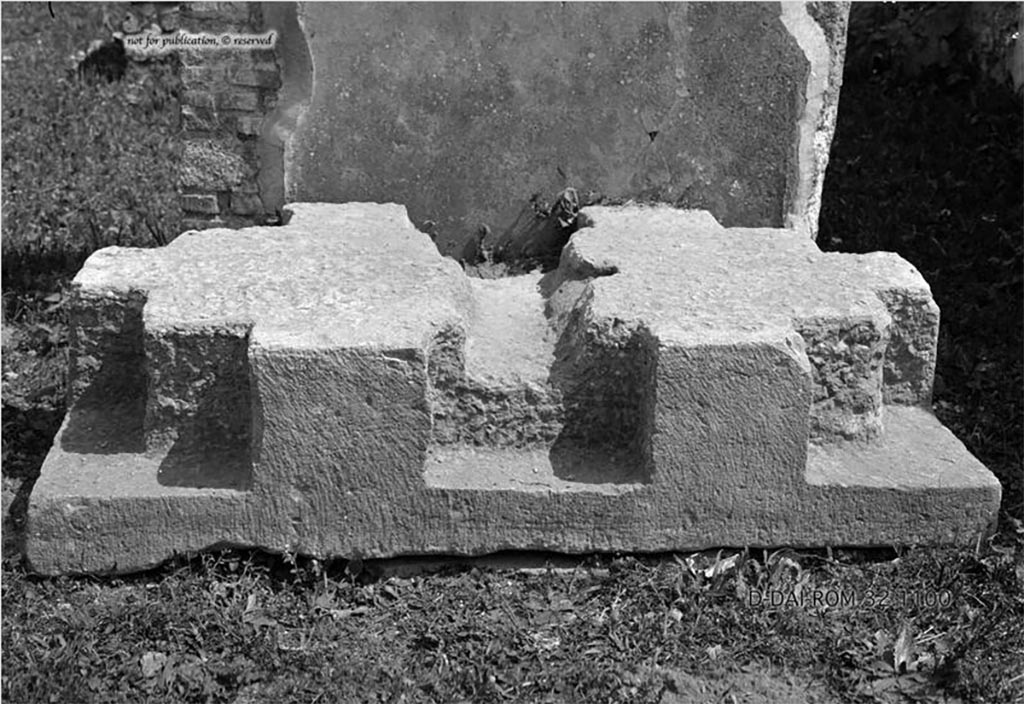 VI.9.1/14 Pompeii. Chest base. Found in the atrium.
According to Pernice –
The stone is notched at right angles at the four corners and has a strong notch on the front for a third foot.
From this notch a deep groove runs across the pedestal (this probably took a strong wooden beam that was placed under the bottom of the box and thus increased the firm connection between the base and the box).
To the right of the groove is a square hole with traces of iron for a spike that went through the bottom of the box.
See Pernice, E., 1932. Hellenistische Tische, Zisternenmündungen, Beckenuntersätze, Altäre u. Truhen. Berlin, p. 73, Taf. 44.2.
DAIR 32.1100. Photo © Deutsches Archäologisches Institut, Abteilung Rom, Arkiv.
Thanks to Espen B. Andersson for assisting us in our interest in money-chests.