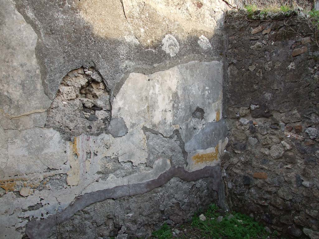 VI.11.19 Pompeii. December 2007. East wall of the room (9) cubiculum, the middle room on south side of the atrium.
This room was described as having a black zoccolo (the lower part of wall).
The white middle background to the wall had painted square panels of yellow and red, the upper wall was white with red panels.