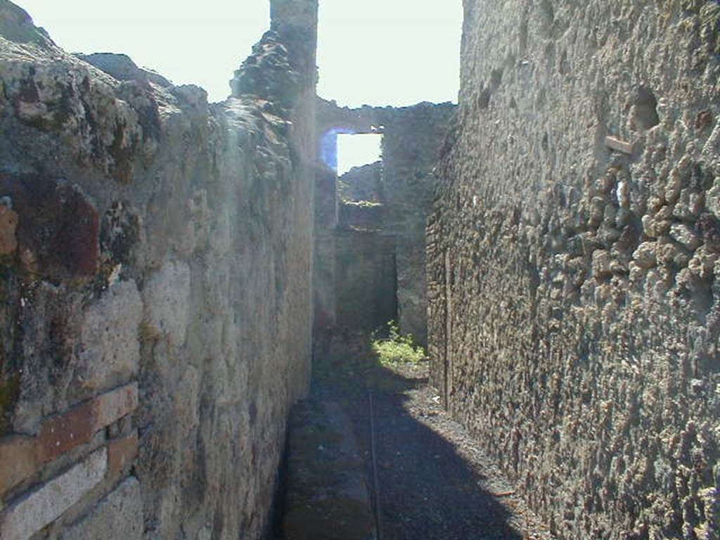 VI.14.27 Pompeii. September 2004. Looking west along entrance corridor towards a doorway leading to the small room, perhaps the kitchen, in the south-west corner of the atrium. The room above would have been accessible by stairs leaning against the south wall of the atrium.

According to Wallace-Hadrill, this corridor led to the atrium and five rooms, wine containers were found at the rear. It was thought to be an establishment of a vinarius (wine-dealer). No decoration was found in any room.
See Wallace-Hadrill, A. (1994): Houses and Society in Pompeii and Herculaneum. Princeton Univ. Pr., (p.213) 

According to Della Corte, this house was named following the discovery of a seal/signet belonging to � M. Memmius Auctus   [CIL X 8058, 50]
See Della Corte, M., 1965.  Case ed Abitanti di Pompei. Napoli: Fausto Fiorentino. (p.96, S.59 with Note 1)

According to Jashemski, in a small courtyard at the rear of the house, excavated in 1875, four small marble busts of philosophers were found. They are now in Naples Archaeological Museum with inventory numbers 110872-110875. They had been cut down, as if to be placed back to back as double-herms, but no two herms, according to Dwyer, seemed to fit together. Perhaps they were being stored here. There were also four terracotta dolias embedded in the soil.
See Jashemski, W. F., 1993. The Gardens of Pompeii, Volume II: Appendices. New York: Caratzas. (p.150)
See Dwyer: Pomp Sculpture, p.128. 

According to Garcia y Garcia, several dividing and perimeter walls were destroyed due to the 1943 bombing. Also the impluvium and stairs to the south of the atrium, and the collapse of the omaba in the west wall of the large room to the north of the atrium, that now appears open never having been built again.
See Garcia y Garcia, L., 2006. Danni di guerra a Pompei. Rome: L�Erma di Bretschneider. (p.91)
