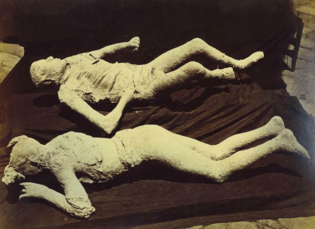 Plaster cast of a supine man with arms and legs slightly contracted, wrapped in a cloak. He was found next to the woman with her tunic raised over her head. Found 23rd April 1875 in north-east corner of VI.14 in middle of Via Stabiana, four metres above ground level in the ash layer. Photo courtesy of Rick Bauer