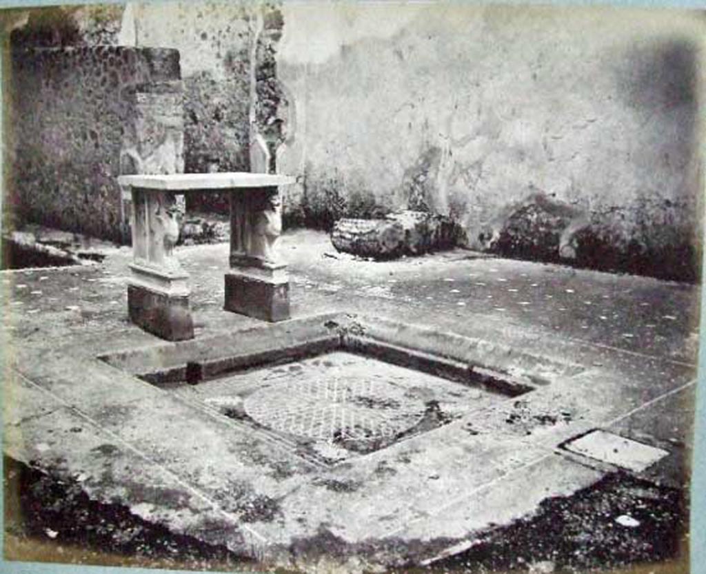 VI.14.39 Pompeii. Casa Lucrum Gaudium or Officina di tornitore.
Looking south-east across atrium and tablinum, showing how it looked before bombing in 1943.
Old undated photograph courtesy of the Society of Antiquaries, Fox Collection.
According to Mau in BdI, the floor of the atrium was made of opus Signinum with crushed lava.
Near to the impluvium was a vent covered by a piece of square stone.
The rim of the impluvium was made of the same opus Signinum as the atrium floor, but with white stones.
In the front rim, between a line of white stones that surrounded it, one could read in letters not very regular, the words – LVCRVM GAVDIVM
At the rear were the two table legs, supported on a brick base which was painted red (0.25 high).
The base of each leg was marble and shaped like a griffin with a lion’s head.
See Mau in Bullettino dell’Instituto di Corrispondenza Archeologica (DAIR), 1878, (p.90).