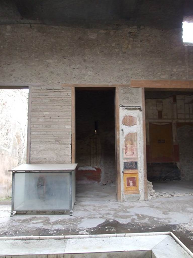 VI.15.1 Pompeii. December 2006. Looking south across atrium, towards glass case.
This contained an iron and bronze strongbox or safe. This was being restored as at December 2006.
According to Della Corte, found in the inside of the house were two bronze seals and a bronze finger ring:
A. Vettius Restitutus (S.100 on page 470)
A. Vettius Conviva (S.98 on page 470)
A. V(ettius) Co(nviva) (S.99 on page 470)
See Della Corte, M., 1965. Case ed Abitanti di Pompei. Napoli: Fausto Fiorentino. (p.67)
According to NdS, on 10th December 1894, the strongbox was found in fragments, on the left side of the impluvium. It was then reconstructed. On 11th December 1894, near the strongbox, two bronze seals were discovered.