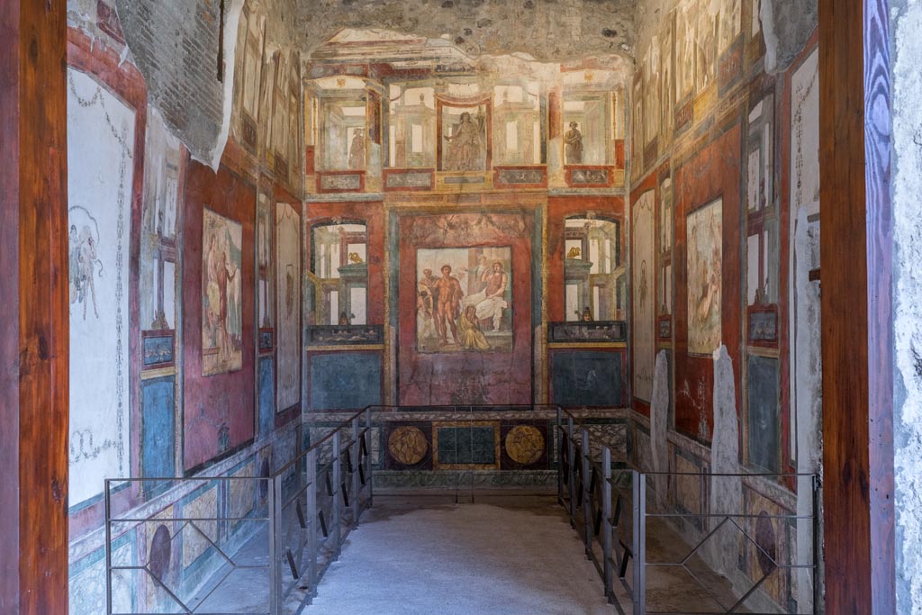 VI.15.1 Pompeii. March 2023.
Looking east through doorway into exedra in north-east corner of peristyle. Photo courtesy of Johannes Eber.