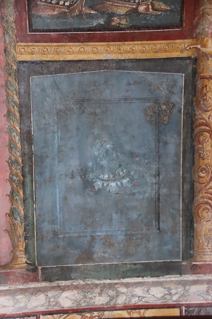VI.15.1 Pompeii. October 2023.
North wall of exedra, painted panel below naval scene. Photo courtesy of Klaus Heese.