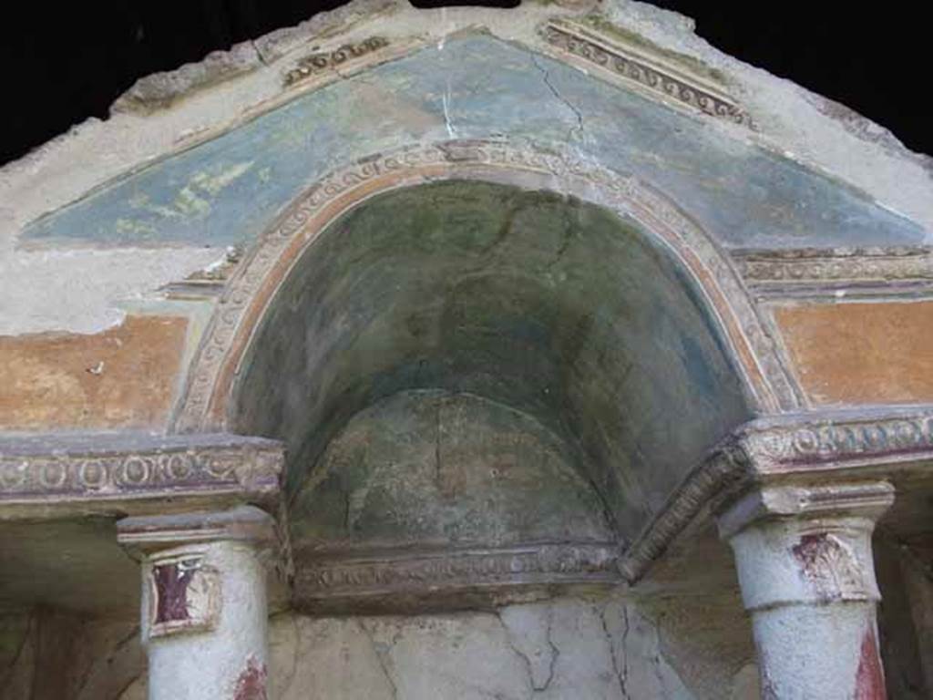 VI.15.8 Pompeii. May 2010. Detail of pediment and stucco on household shrine in the garden.