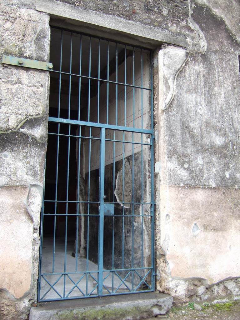 VI.15.8 Pompeii. December 2007. Entrance with painted wall on north side of entrance corridor.
According to NdS –
the walls of the fauces, or entrance corridor, were decorated on a white background, which was then partitioned with black and red lines.
The high dado, or ‘zoccolo’ was painted black.
