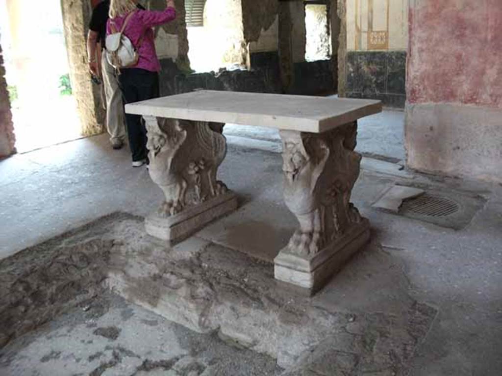 VI.15.8 Pompeii. May 2010. Marble table in atrium, supported by two legs decorated with flying animals with lion’s paws.