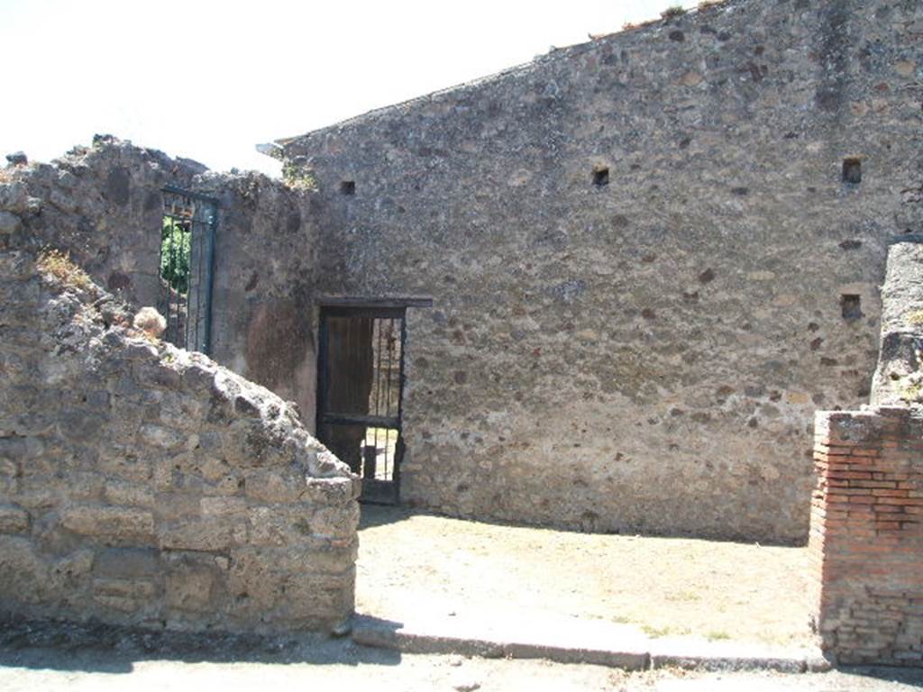 VI.16.19 Pompeii. May 2005. Looking west towards entrance doorway on Via Stabiana into room H, on plan of VI.16.26/27/19. On the left can be seen a doorway to room I, ala, and centre left can be seen the doorway to room H. According to NdS, on the left end of the west wall there was a small doorway that led from room H into room G, triclinium. Room H was of an irregular shape, and on its northern wall and partly on its western wall, preserved remains of large panels with a red background, offering instead on the southern wall, a simple coating of plaster (intonaco laterizio). See Notizie degli Scavi di Antichit�, 1908, (p.188).
