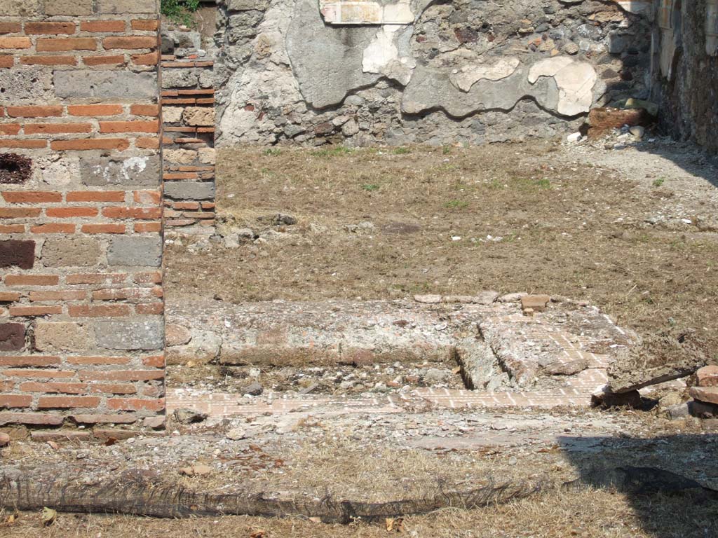 VI.16.26 Pompeii. May 2006. Looking east across impluvium in atrium.
According to NdS, the square shaped impluvium had its base covered with Opus signinum with numerous pieces of marble randomly buried into it.
The sides were covered with plaster (intonaco laterizio) and a wide border of cocciopesto with a lovely design of meander made with white tesserae.
The atrium floor was of cocciopesto.