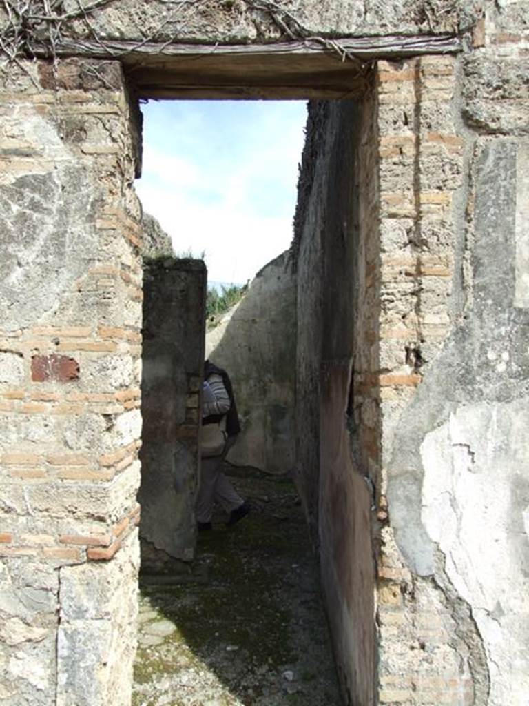 VI.16.28 Pompeii. March 2009. Doorway to rooms G and H. According to NdS, to the side of the tablinum were two rather narrow rooms, with lava threshold and showed remains of wood towards the atrium. The doorway on the left, which preserved in the threshold the two iron hinges, led into room G, which was a small rustic room. Its floor was made of cocciopesto, and had rough plaster on the walls, except on the south wall which formed a continuation from the atrium.  See Notizie degli Scavi di Antichit�, 1908, (p.277)
