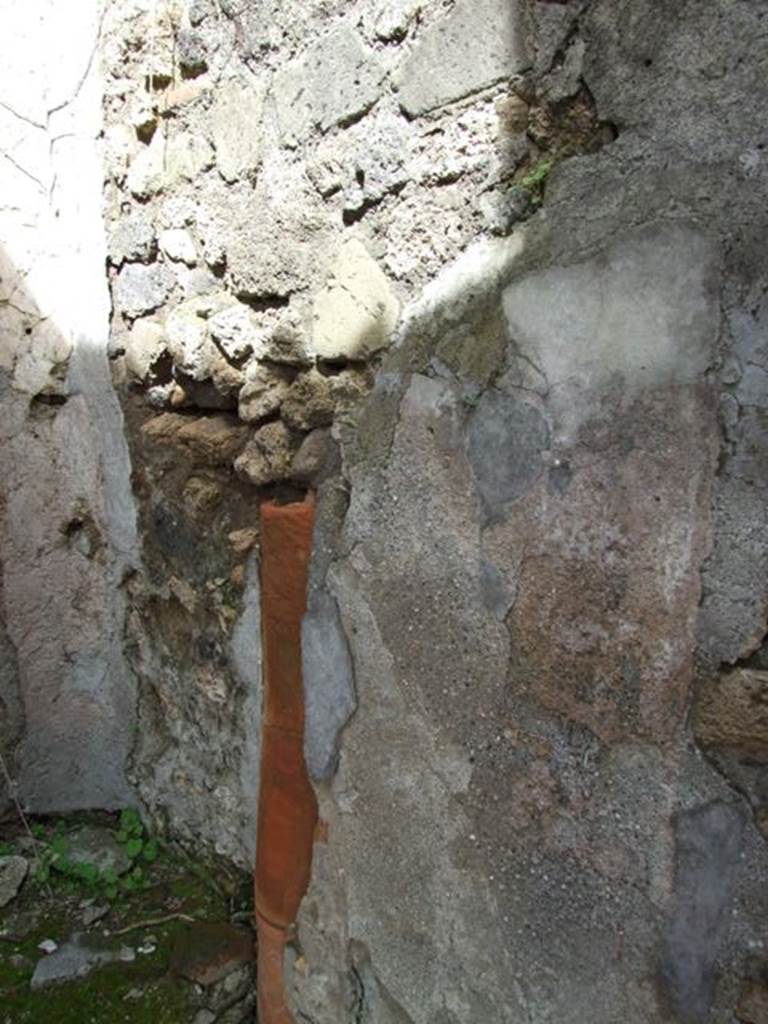 VI.16.28 Pompeii. March 2009. Room G, east wall with down pipe. According to Hobson, there are three down-pipes in this property, two of which may be associated with upper floor latrines. See Hobson, B. 2009. Pompeii, Latrines and Down Pipes. Oxford, Hadrian Books, (p.290, 294-5) According to NdS, in the east wall there was a terracotta down-pipe descending from the upper floor. In the height of the north wall, there were holes for supporting the beams of an upper mezzanine. See Notizie degli Scavi di Antichit�, 1908, (p.278)
