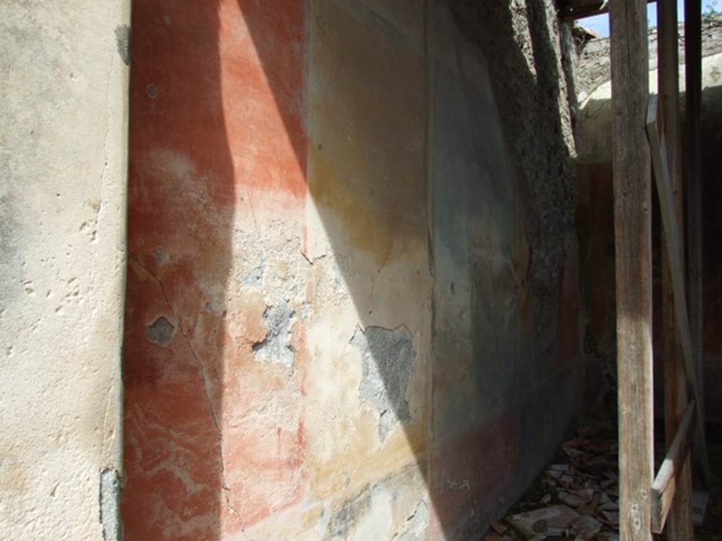 VI.16.28 Pompeii. March 2009. Room F, north wall, showing remains of red, yellow and green panels. According to NdS, The wall was divided into five parts, the central panel was green, the two either side of it were yellow, and the two at the ends were red. The central panel had a painting and was separated from the side panels by two slender columns. The panels of the north wall are divided by simple blackish bands. The upper zone had a white background and preserved a small part of the architectural decoration, and was of the third style. The dado had a red zone in correspondence with the central panel, and two black in correspondence with the four large side panels. See Notizie degli Scavi di Antichit�, 1908, (p.273-4). According to PPP, in the centre of this wall was a painting of the Hunt of the Bulls, from which the house was also named. See Bragantini, de Vos, Badoni, 1983. Pitture e Pavimenti di Pompei, Parte 2. Rome: ICCD. (p.368).