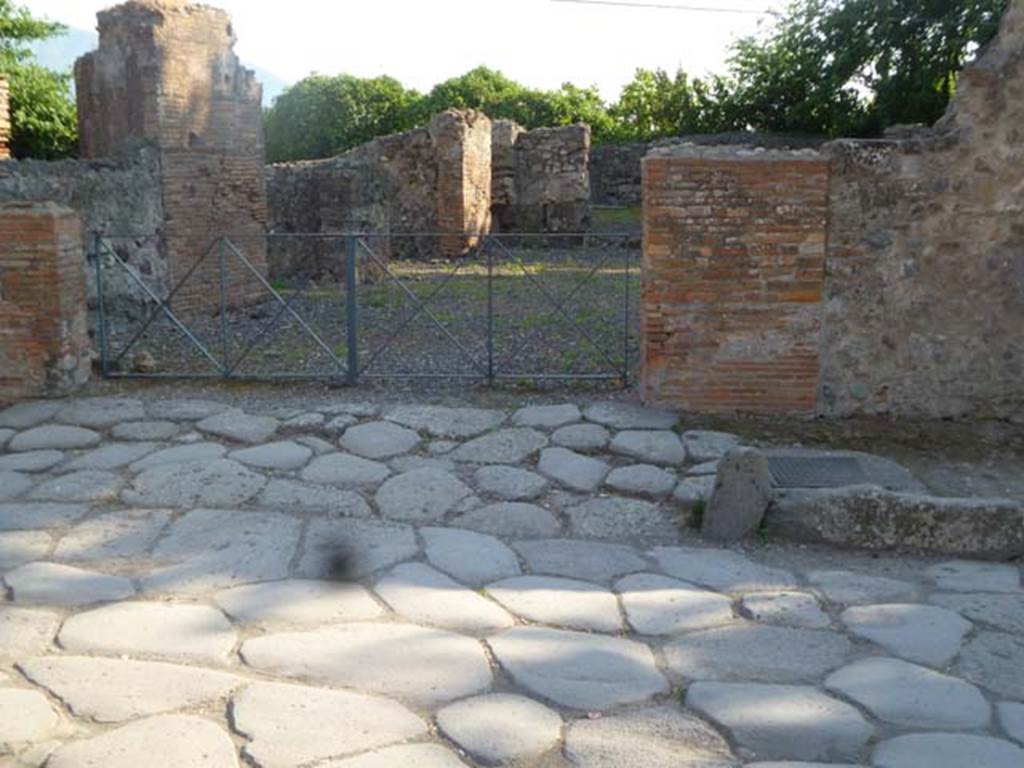 VI.17.1 Pompeii. May 2011. Looking west towards ramp leading to entrance.
According to Fiorelli, the first entrance commencing from the Herculaneum Gate was an inn with annexed bar. Recognisable by the lowered ramp for the access of the wagons and animals, by the wide doorway introducing into an area, that had on the right the kitchen, the shelter for the vehicles, the stable, the latrine, and a large room from which one went down to the cellar and passed in a space enclosed between the city gate and the city wall, used for the rubbish, where various animal bones were found. On the left and in front of it were dormitories, and maybe even dining areas.
See Pappalardo, U., 2001. La Descrizione di Pompei per Giuseppe Fiorelli (1875). Napoli: Massa Editore. (p.158)
See PAH, 1,1,236 (30th December 1769) with addendum 154, and PAH 1,1,238 (5th May 1770), with addendum 155.