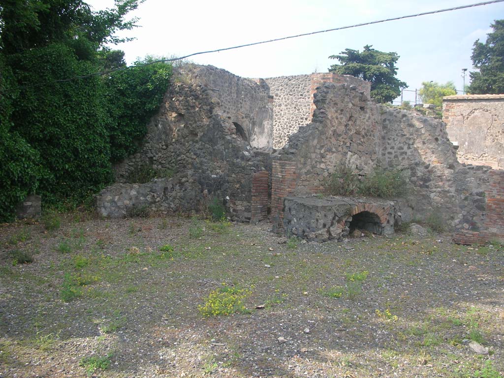 VI.17.1 Pompeii. May 2010.
Looking north-east towards doorway to small room, latrine or corridor near east wall, in centre, and hearth in kitchen against north wall.
Photo courtesy of Ivo van der Graaff.