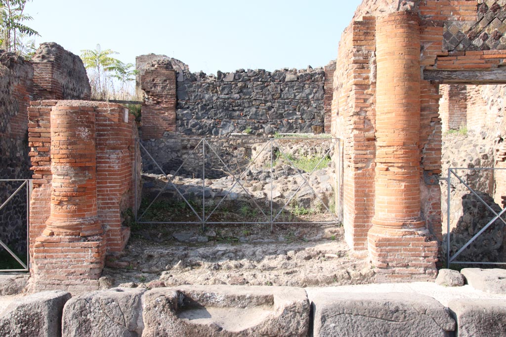 VI.17.36 Pompeii. October 2023.
Looking west past step cut in kerb to entrance doorway with a brick half round column on each side. Photo courtesy of Klaus Heese.