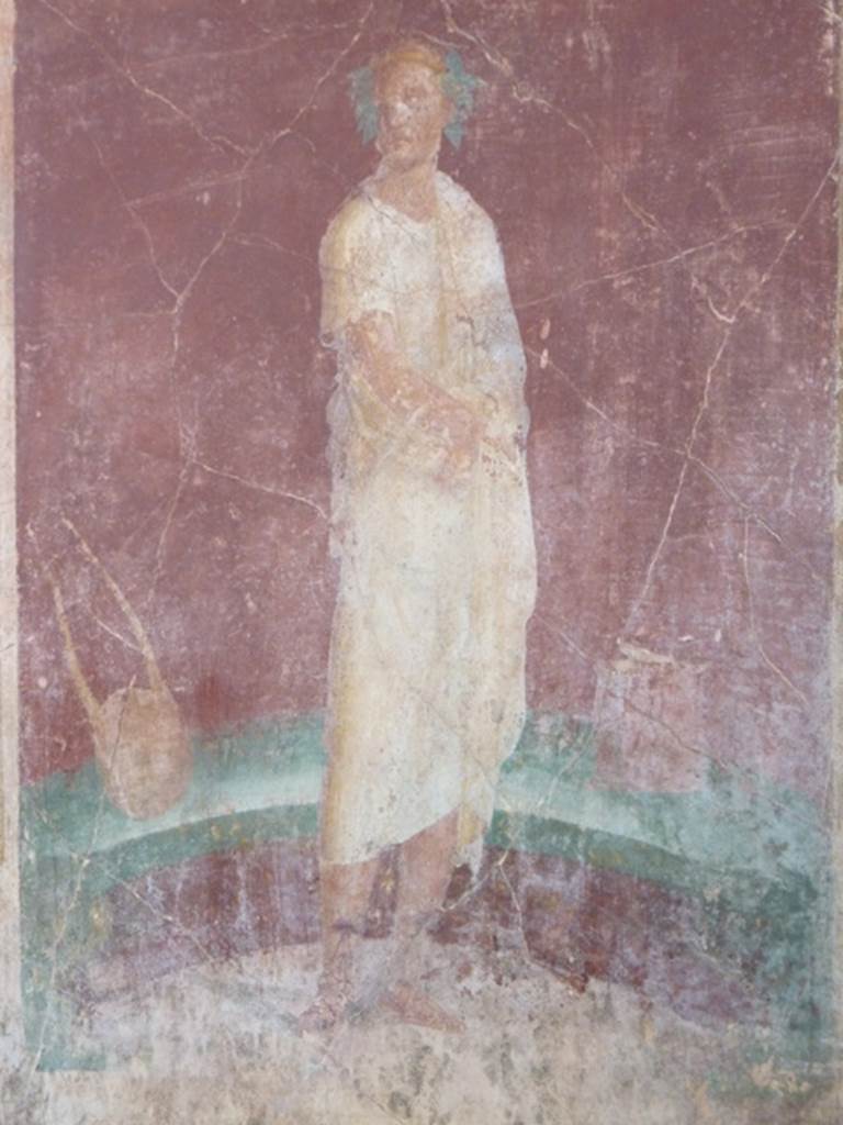VI.17.41 Pompeii. October 2010. east wall of exedra 18 on north side of cubiculum 17.
Detail of painting of robed figure with instruments. Photo courtesy of Gaby Große.