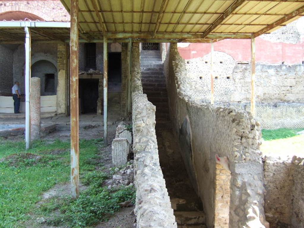 VI.17.42 Pompeii. May 2006. Garden, on left, and corridor and garden of VII.16.22 House of Fabius Rufus, on right. At the rear of the garden, on the left, is the corridor where the group of fugitives would have been found.