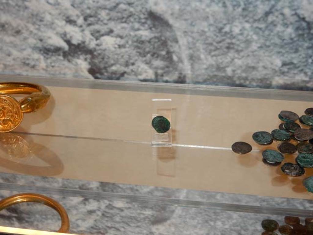 VI.17.42 Pompeii, May 2018. Detail of shelf with bracelet, single silver and pile of silver coins.
Photo courtesy of Buzz Ferebee.