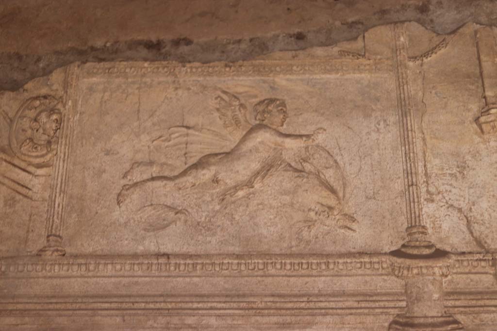 VII.1.8 Pompeii. September 2017. Detail of stuccoed cupid from north end of east wall of men’s changing room 2. Photo courtesy of Klaus Heese.