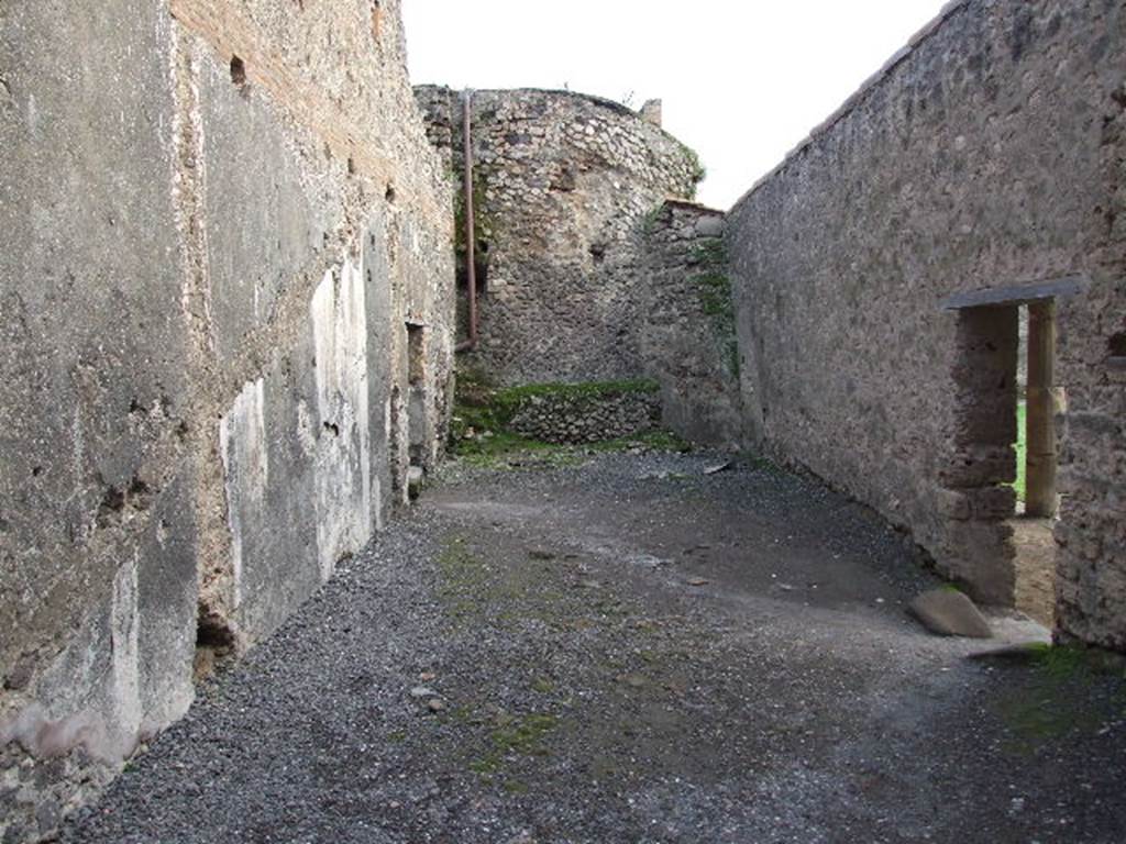VII.1.8 Pompeii. December 2007. Room 8, anteroom of women�s baths, looking south from changing room 11. Doorway leading to praefurnium 7 is on left. Doorway to east portico B and gymnasium C is on right. According to Boyce, on the east wall (left), was a painted single serpent coiling towards an altar with offerings. He described it as being above the small arched opening that passed the conduit that supplied water for the labrum of the women�s calidarium 9. This would be somewhere in the vicinity of the large white patch on the wall. See Boyce G. K., 1937. Corpus of the Lararia of Pompeii. Rome: MAAR 14.  (p. 95, 472).
 
