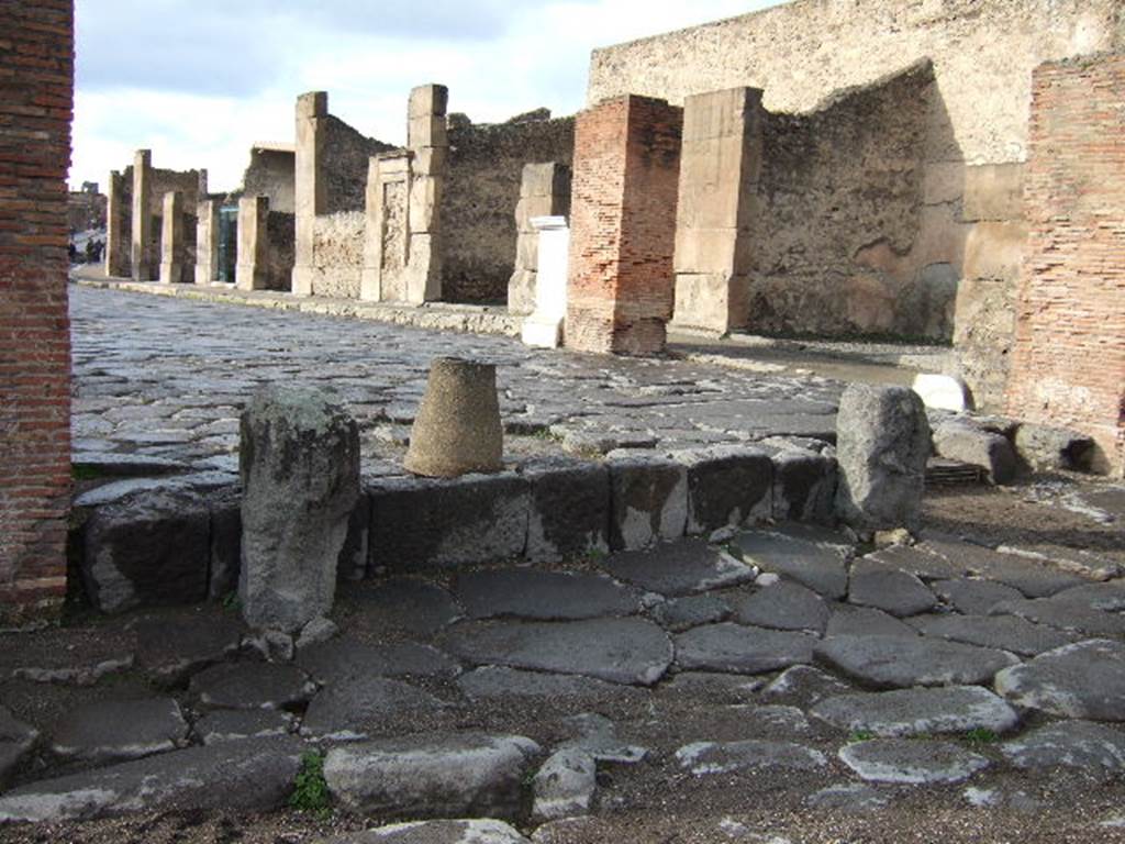 Looking west along Via dell� Abbondanza, Pompeii.  VII.1.12 is first shop on right, near where the statue of Holconius Rufus was found (the white marble pedestal).
