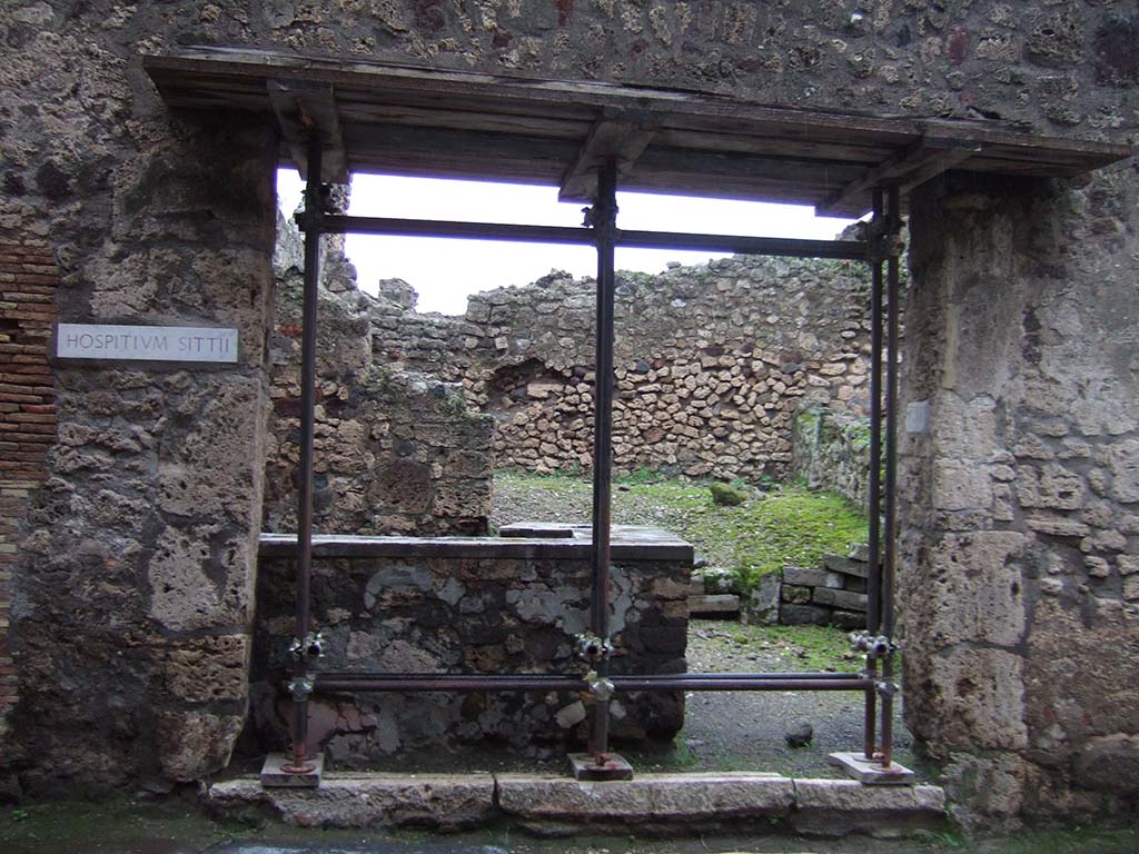 VII.1.44 Pompeii. December 2005. Looking east to entrance.
The hospitium had two doorways divided by a central pilaster, seen on the right above.
This pilaster was painted with the sign of an elephant surrounded around its body by a huge serpent and being rescued by a pigmy.
Above was a graffiti which possibly identified the owner as Sittius, who boasted that he had restored the elephant.
SITTIVS  RESTITVIT  ELEPHANTVM     [CIL IV 806]
Underneath was an advert
HOSPITIVM  HIC  LOCATVR
TRICLINIVM  CVM  TRIBVS LECTIS
ET  COMM(odis)     [CIL IV 807]
See Dobbins, J & Foss, P., 2008. The World of Pompeii. New York: Routledge. (p.477)

Mau thought 
Sittius restituit elephantu(m)  [CIL IV 806]   (Sittius restored the elephant) was referring to the repainting of the sign.
He thought the owner, whether Sittius or an unknown, was keen to rent the premises as under the elephant was the painted notice
Hospitium hic locatur - triclinium cum tribus lectis  [CIL IV 807]   (Inn to let � triclinium with 3 couches). 
Mau said the rest of the inscription was illegible.
See Mau, A., 1907, translated by Kelsey F. W. Pompeii: Its Life and Art. New York: Macmillan. (p.400)
